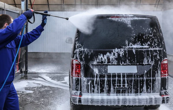 Trabajador de limpieza de automóviles con chorro de agua de alta presión en el coche w — Foto de Stock