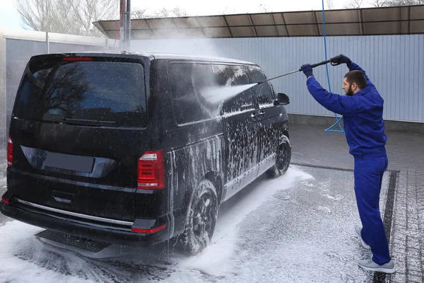 Trabajador de limpieza de automóviles con chorro de agua de alta presión en el coche w — Foto de Stock