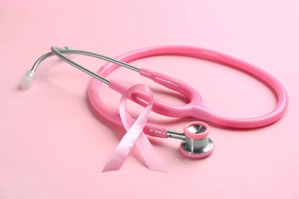 Розовая лента и стетоскоп на цветном фоне. Рак молочной железы c — стоковое фото