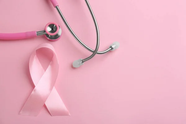 Pink ribbon and stethoscope on color background, flat lay with s — 스톡 사진