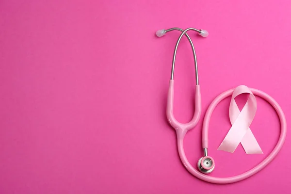 Pink ribbon and stethoscope on color background, flat lay with s — 스톡 사진