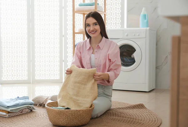 Young woman with clean laundry in bathroom — Stock Photo, Image