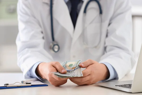 Doutor com suborno na mesa na clínica, close up. Medicamento corrompido — Fotografia de Stock