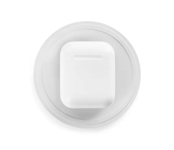 Écouteurs rechargeables avec pad sans fil isolé sur blanc, vue de dessus — Photo