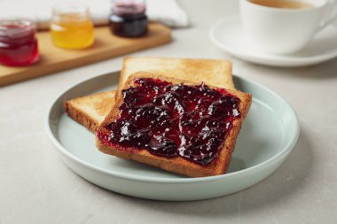 Delicious crispy toasts with jam on table