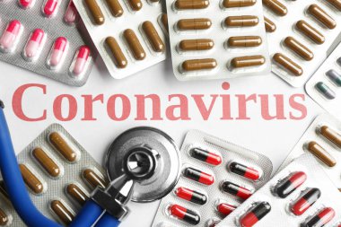 Beyaz arka planda Coronavirus kelimesi, steteskop ve tıp ile kompozisyon, üst görünüm