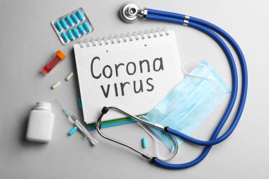 Açık gri arka planda Corona Virüsü, steteskop ve tıp kelimeleriyle düz kompozisyon