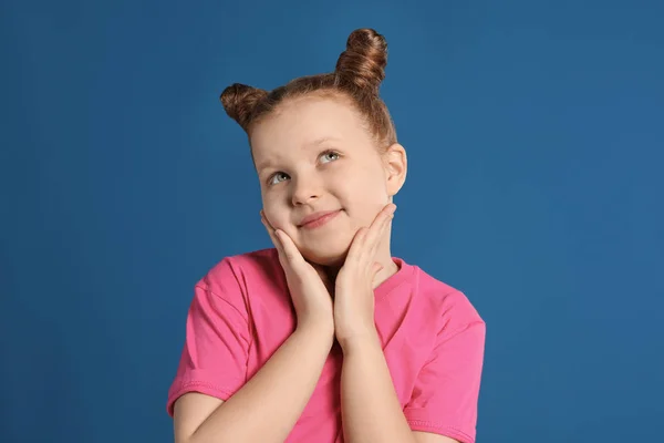 Портрет маленькой девочки на синем фоне — стоковое фото