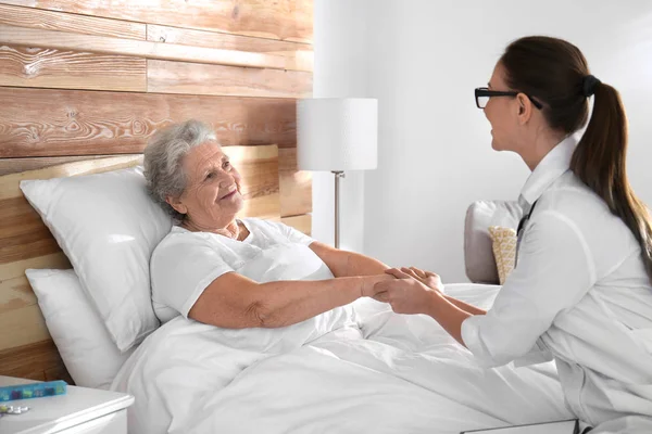 Arzt besucht Seniorin in modernem Krankenhaus — Stockfoto