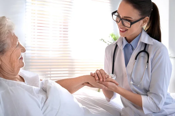 Médico visitando a paciente mayor en hospital moderno — Foto de Stock