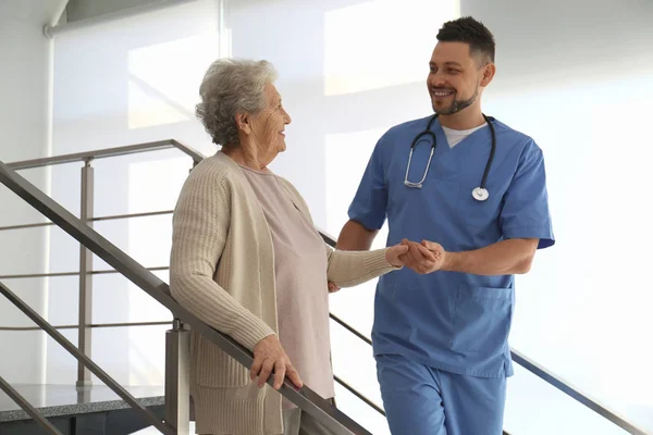 Medico che aiuta il paziente anziano nell'ospedale moderno — Foto Stock