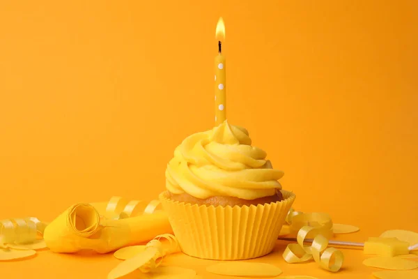 Délicieux cupcake d'anniversaire avec bougie allumée sur fond jaune — Photo