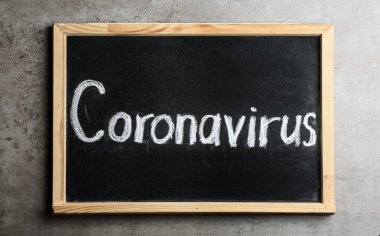 Açık gri taş masa üzerinde Coronavirus yazan karatahta, üst görünüm