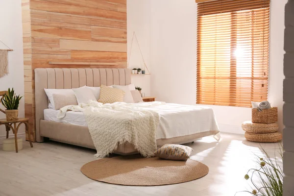 Стильный интерьер комнаты с большой удобной кроватью — стоковое фото