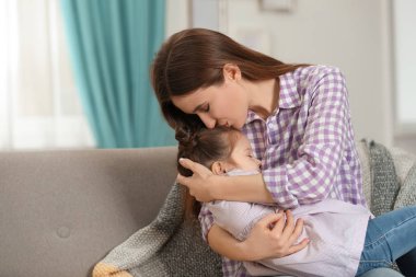 Young mother with little daughter at home