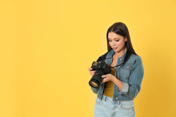 Fotógrafo profissional trabalhando em fundo amarelo em estúdio — Fotografia de Stock