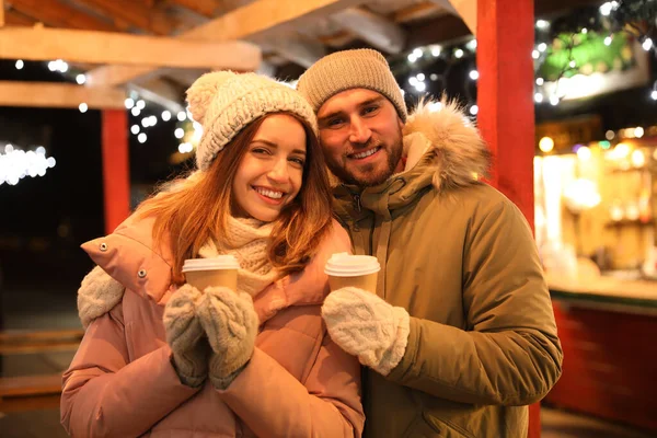 Boldog pár italokkal a karácsonyi vásáron — Stock Fotó