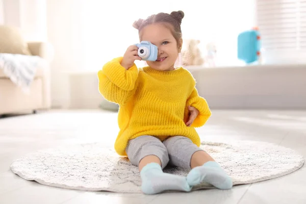 Liten fotograf tar bild med leksak kamera hemma — Stockfoto