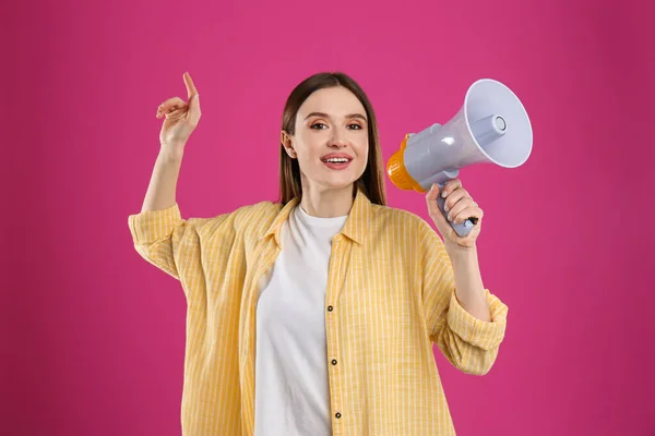 Mladá žena s megafonem na růžovém pozadí — Stock fotografie