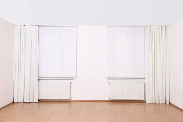 Janelas com cortinas elegantes e persianas em sala vazia — Fotografia de Stock