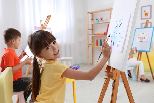 Niedliches kleines Kind malt während des Unterrichts im Zimmer — Stockfoto