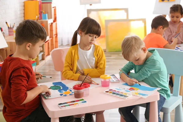 Cute little children painting at table in room — Stock Photo, Image