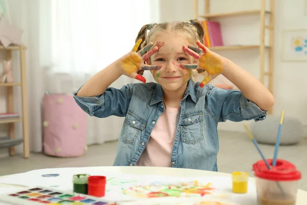 Roztomilé dítě malování s dlaněmi u stolu — Stock fotografie