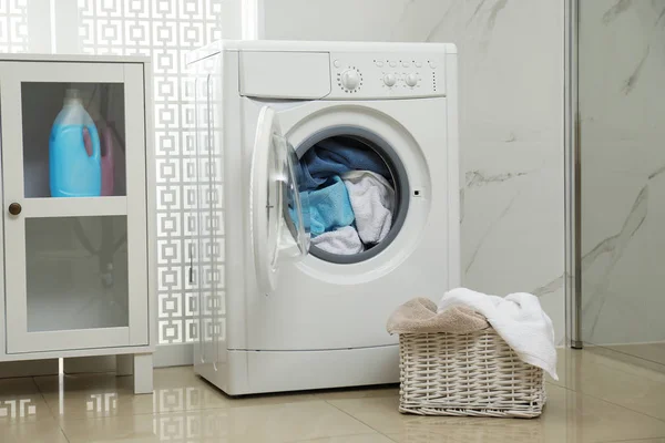 Modern tvättmaskin med handdukar i badrum — Stockfoto