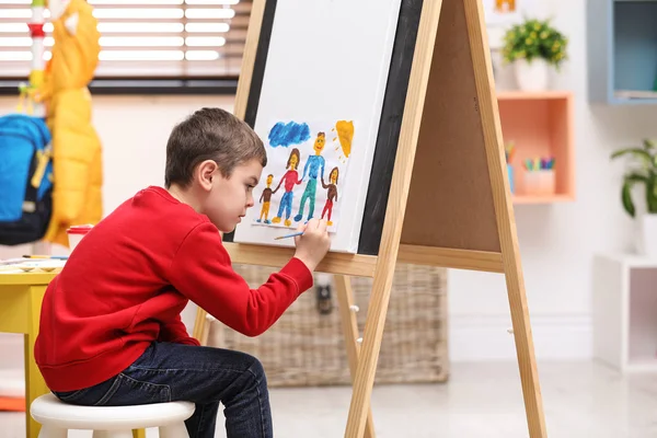 Little child painting on easel in room — ストック写真