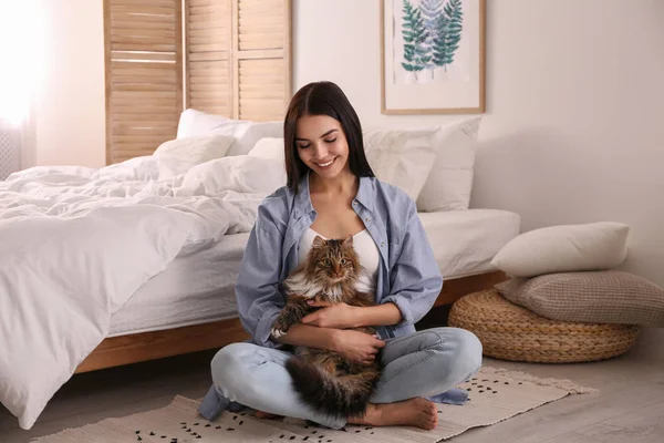 Mooie jonge vrouw met haar schattige kat op de vloer in de slaapkamer. Griep — Stockfoto