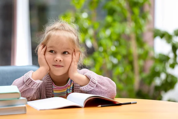 Linda niña estudiando en la mesa de madera en el interior. Espacio para tex — Foto de Stock