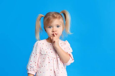 mavi arka plan üzerinde sevimli küçük kız portresi