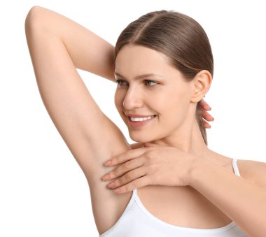 Genç ve güzel bir kadın, beyaz arka planda pürüzsüz, temiz bir ciltle koltukaltı gösteriyor.