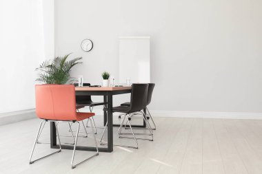 Büyük masası ve sandalyeleri olan basit bir ofis.