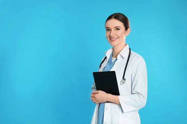 Doktor se stetoskopem a schránkou na modrém pozadí. Mezera — Stock fotografie