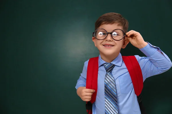 Mignon petit enfant portant des lunettes près du tableau, espace pour tex — Photo