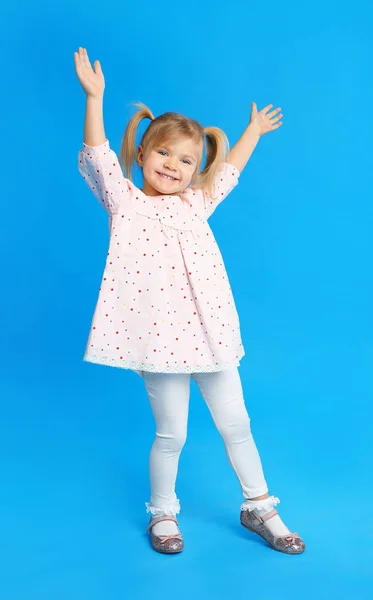 Портрет милої маленької дівчинки на синьому фоні — стокове фото