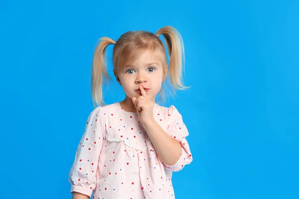 Porträtt av söt liten flicka på blå bakgrund — Stockfoto