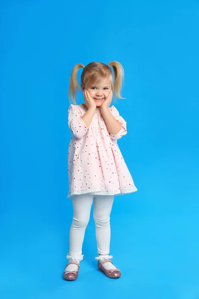 Portret van schattig klein meisje op blauwe achtergrond — Stockfoto