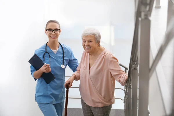 Врач помогает пожилым пациентам в современной больнице — стоковое фото