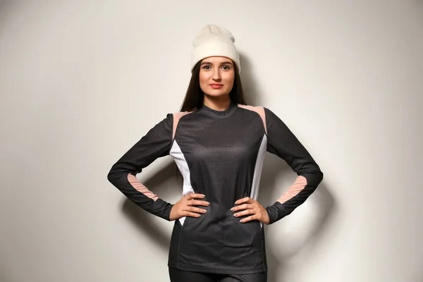Wanita mengenakan pakaian dalam termal dan topi pada latar belakang abu-abu terang — Stok Foto