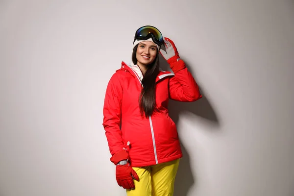 Жінка в стильному зимовому спортивному одязі на світло-сірому фоні — стокове фото