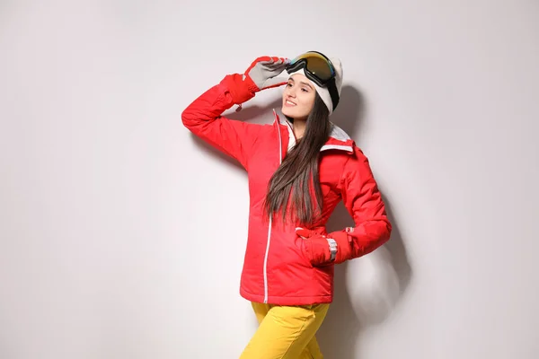 Γυναίκα φορώντας κομψά ρούχα χειμερινό άθλημα σε ανοιχτό γκρι backgro — Φωτογραφία Αρχείου