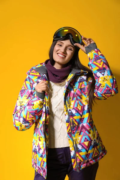 Femme portant des vêtements de sport d'hiver élégants sur fond jaune — Photo