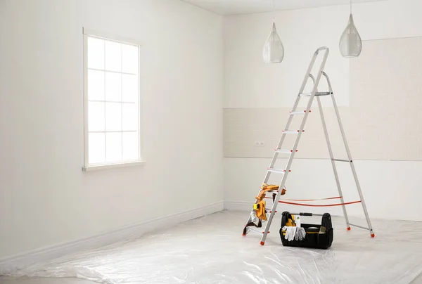 Escalera y diferentes herramientas cerca de la pared en la habitación. Renov Interior — Foto de Stock