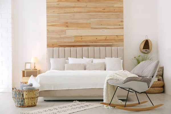 Стильный интерьер комнаты с большой удобной кроватью — стоковое фото