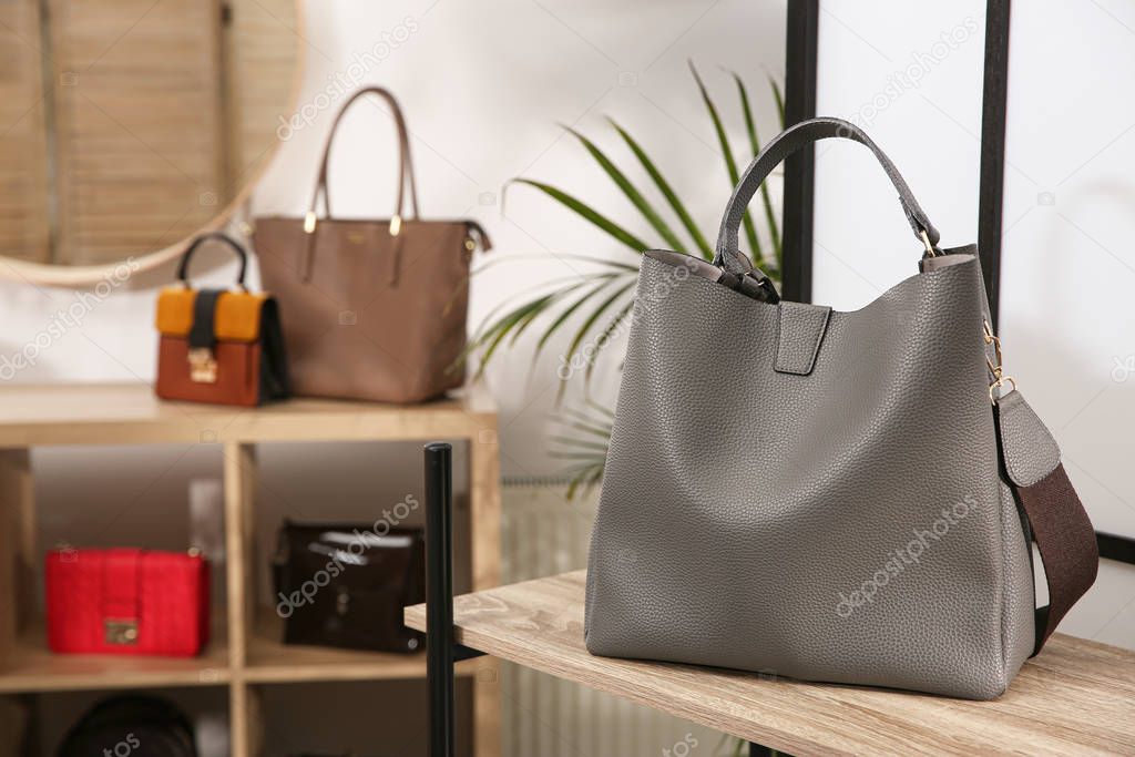 Grey woman's bag on wooden shelf in store