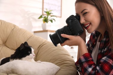 Profesyonel hayvan fotoğrafçısı evde güzel bir kedinin fotoğrafını çekiyor.