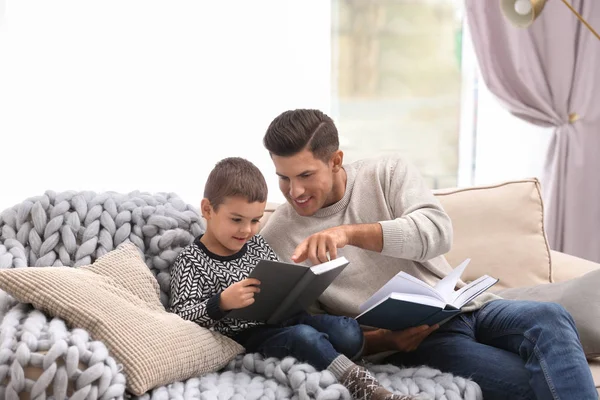 Otec a jeho syn čtou doma knihy. Zimní dovolená — Stock fotografie
