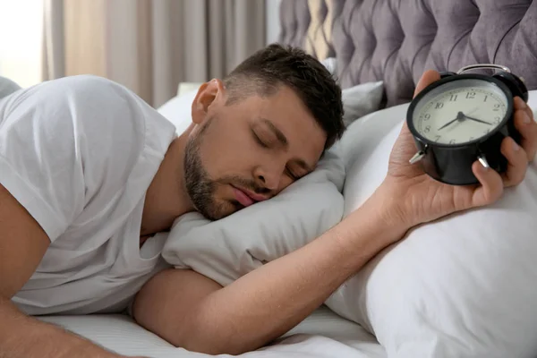 Mann mit Wecker schläft morgens zu Hause — Stockfoto
